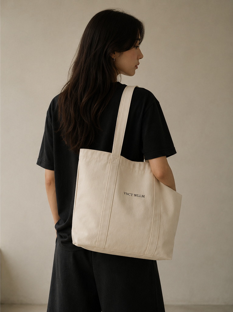 Inaugural Edition Canvas Tote in ivory, carried at the shoulder, seen from behind